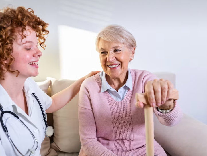 Pflegekraft im Gespräch mit einer Seniorin zu Hause